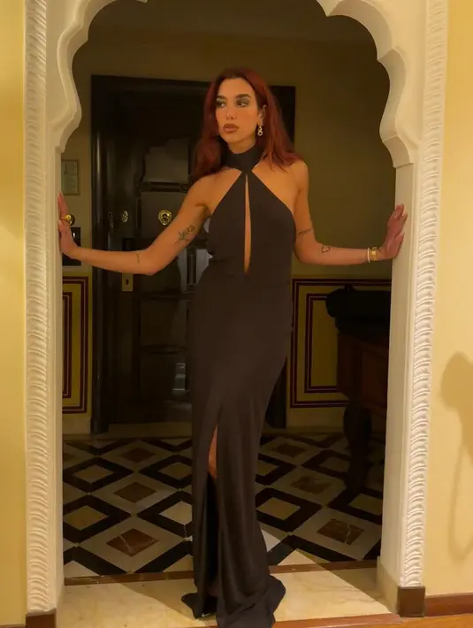 Penampilan slay berikutnya dari Dua Lipa saat ia mengenakan sebuah dress dengan detail halter-neck ini. Dress hitam tanpa lengan dengan cut out di bagian dada depan ini terlihat sangat apik membalut tubuhnya. [Foto: Instagram/dualipa]