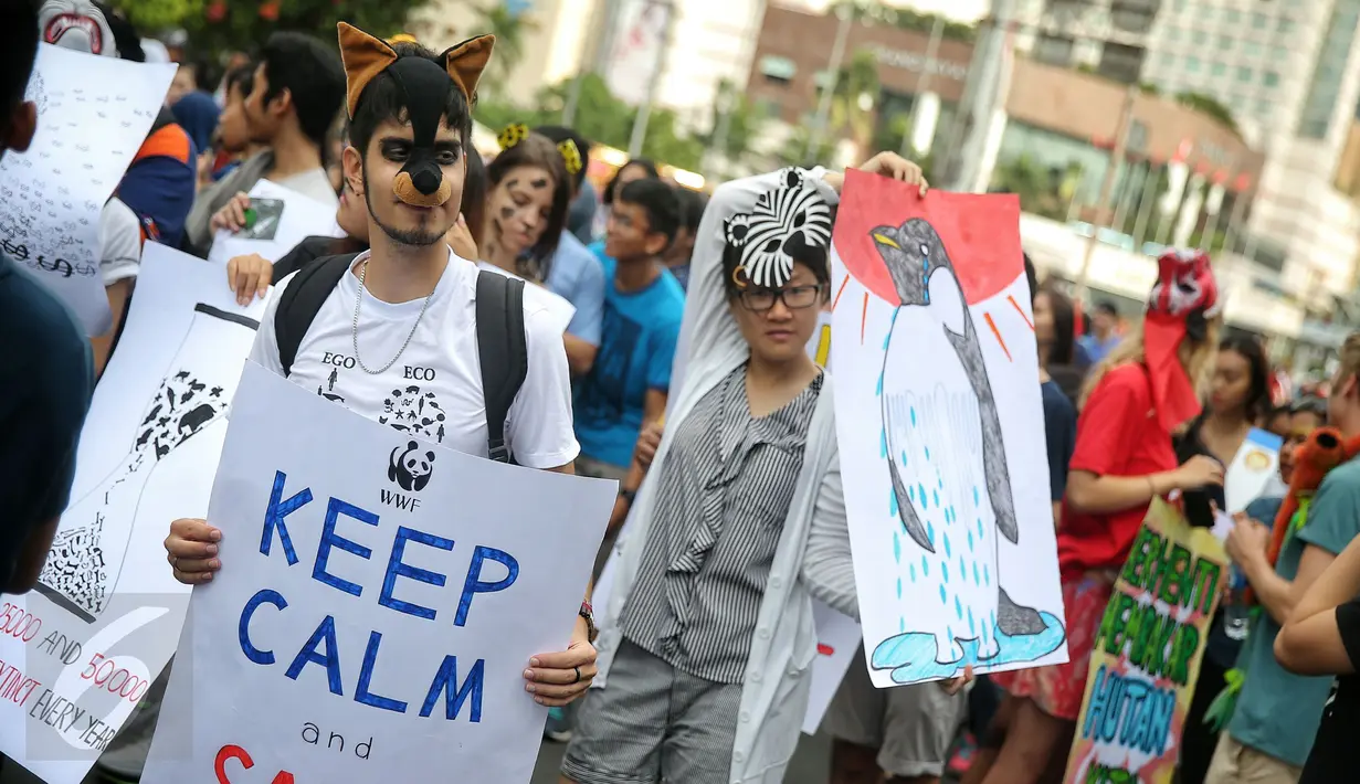 Sejumlah orang membawa poster dan menyerukan "save animal" dalam aksi #SaveAnimal di kawasan Bunderan HI, Jakarta, Minggu (31/1/2016). Dalam aksinya mereka mengecam perburuan binatang dan hentikan pembakaran hutan. (Liputa6.com/Faizal Fanani)