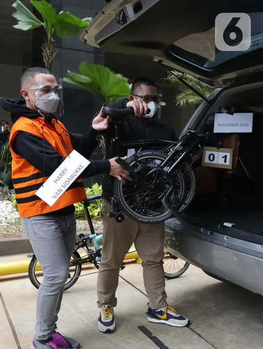 Tersangka Harry Sidabuke (kiri) bersama perantara anggota Komisi II DPR Ihsan Yunus, Agustri Yogasmara memasukkan sepeda ke dalam mobil saat rekonstruksi perkara dugaan korupsi pengadaan bantuan sosial penanganan COVID-19 di gedung KPK, Jakarta, Rabu (10/2/2021). (Liputan6.com/Helmi Fithriansyah)