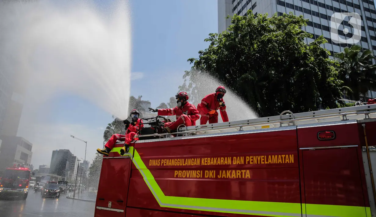 Petugas Dinas Pemadam Kebakaran Pemprov DKI melakukan penyemprotan cairan disinfektan di Jalan Thamrin, Jakarta, Selasa (31/3/2020). Penyemprotan yang dilakukan terus menerus itu untuk meminimalisir penyebaran COVID-19 di ruang udara dan ruas jalan. (Liputan6.com/Faizal Fanani)