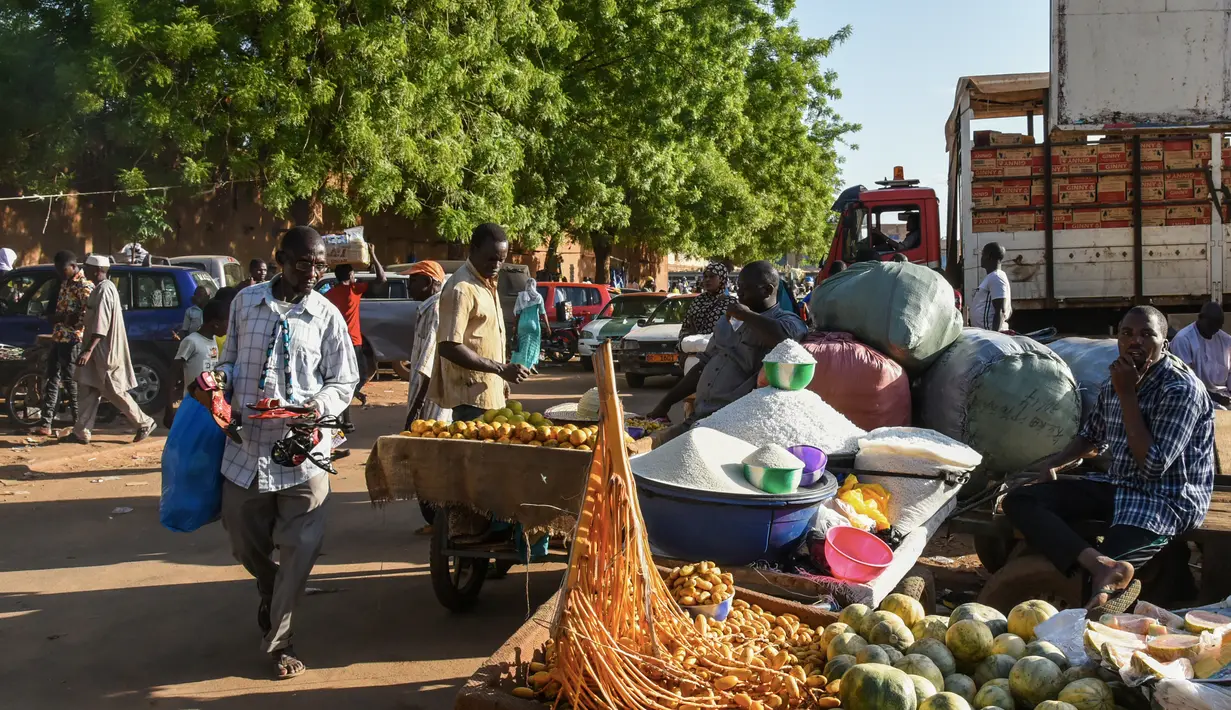 Pedagang kaki lima menjual barang-barang di Niamey, Niger (10/7/2019). Kota ini merupakan pusat administratif, budaya, dan ekonomi di Niger. Industri yang terdapat di kota ini antara lain adalah batu bata, keramik, semen, dan tenun. (AFP Photo/Issouf Sanogo)