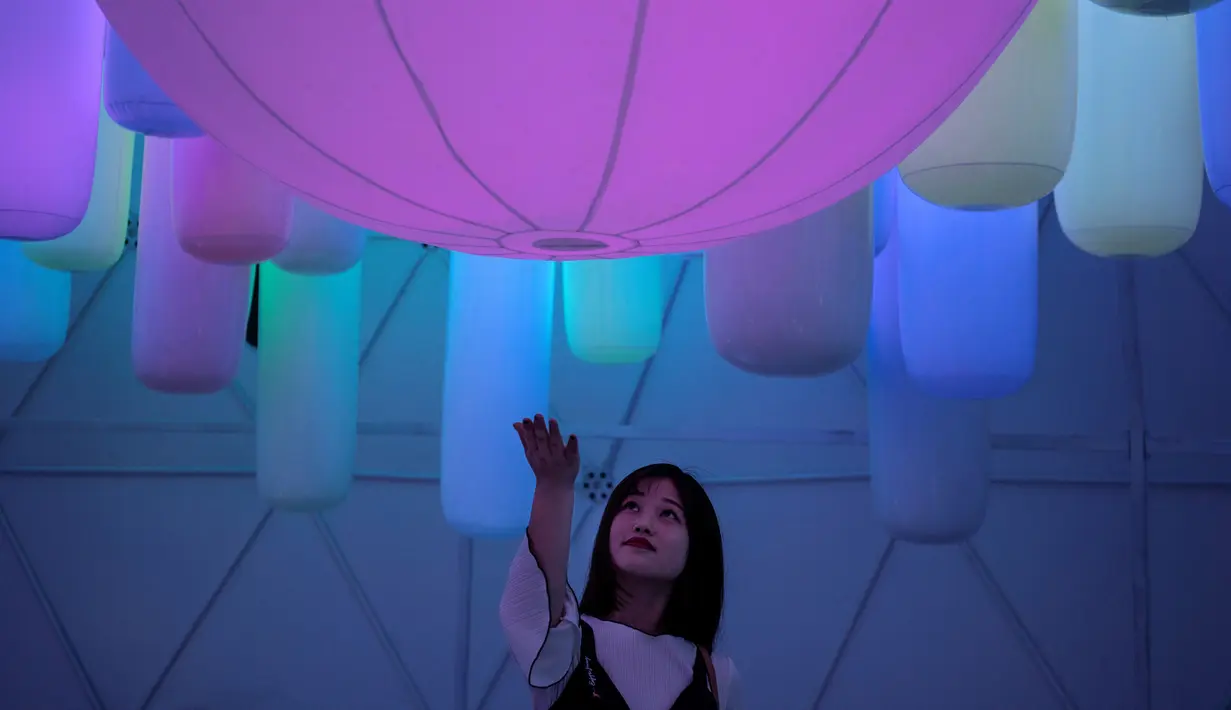 Seorang wanita melihat pameran seni cahaya yang berjudul "Halo Park" di Chaoyang Park, Beijing (7/5). Pameran ini juga menjadi tempat wisata baru di Beijing. (AFP/Fred Dufour)