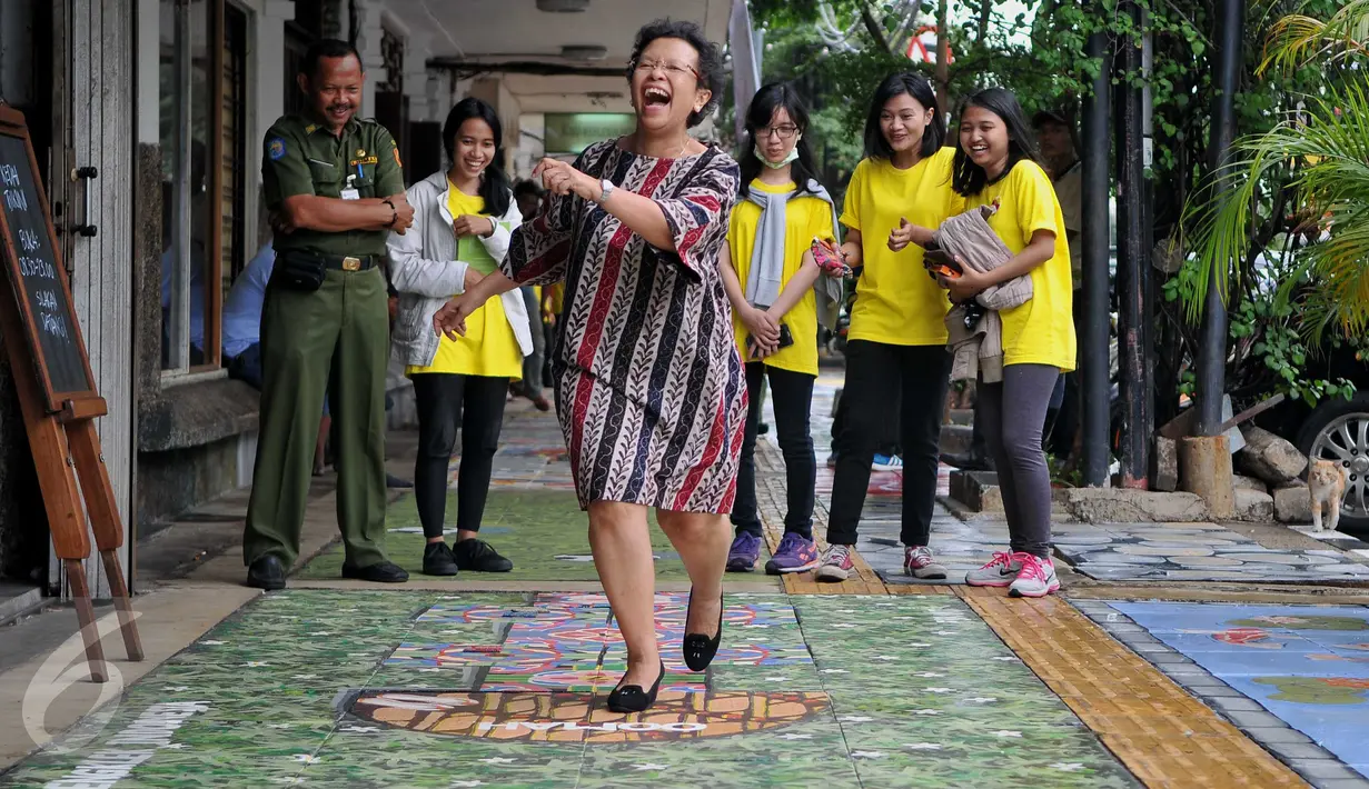 Warga melintas di trotoar Cikini, Jakarta, Senin (14/12/2015). Mural yang dibuat di atas trotoar sepanjang 120 meter ini merupakan rangkaian kegiatan Fun Actv Art Mural 2015. (Liputan6.com/Gempur M Surya)