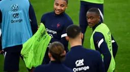 Penyerang Prancis, Christopher Nkunku (tengah) dan Fance Moussa Diaby menghadiri sesi latihan di Stadion Velodrome di Marseille, Prancis selatan (24/3/2022). Prancis akan bertanding melawan Pantai Gading pada pertandingan persahabatan. (AFP/Franck Fife)