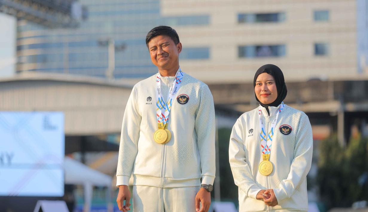 Dalam situasi poin imbang atau deuce, ketenangan Ega Agata Salsabilla menghasilkan poin lebih tinggi dan dipastikan meraih emas. Tampak dalam foto, Atlet panahan Indonesia, Riau Ega Agata Salsabilla (kiri) usai prosesi pengalungan medali SEA Games 2025 di Football Field 1, Sports Authority of Thailand, Bangkok, Rabu (17/12/2025). (Bola.com/Bagaskara Lazuardi)