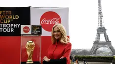 Duta Besar FIFA World Cup 2018, Victoria Lopyreva berpose dengan trofi Piala Dunia dengan latar menara Eiffel selama FIFA World Cup Trophy Tour di Paris (20/3). Piala Dunia 2018 diselenggarakan 14 Juni dan 15 Juli 2018 di Rusia. (AFP Photo/Franck Fife)