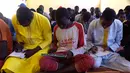 Murid menulis di buku saat menghadiri kelas di sekolah dasar di Pikine, Dakar, (30/1). Pendidikan di Senegal menjadi prioritas saat konferensi ketiga tentang pemulihan dana Kemitraan Global untuk Pendidikan (GPE) mulai 1 Februari 2018. (AFP Photo/Seyllou)