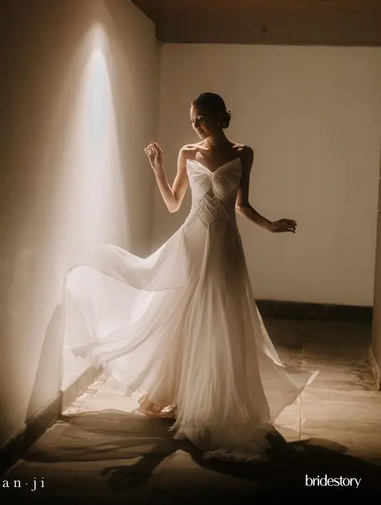 Di resepsi pernikahan, Mikha Tambayong kenakan flowy dress rancangan Jeffy Tan. Dress dengan aksen pita di bagian dada itu terlihat dreamy [@miktambayong]