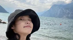 Dengan busana kasual, IU juga menikmati pemandangan tepi laut.  [Foto: Instagram/ dlwlrma]