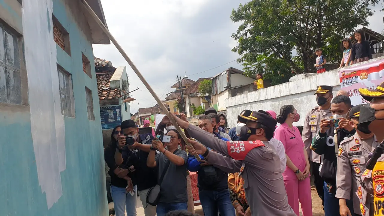 Kapolres Garut AKBP Wirdhanto Hadicaksono, terpaksa menjadi tukang cat dadakan dalam pengecetan musola milik warga di wilayah Garut Kota, Garut di sela-sela rangkaian penyambutan HUT Bhayangkara 2022. (Liputan6.com/Jayadi Supriadin).