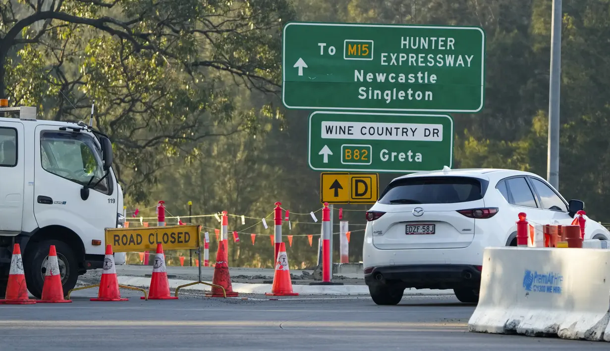 Sebuah penghalang jalan dipasang di dekat kota Greta menyusul kecelakaan bus di Hunter Valley, utara Sydney, Australia, Senin (12/6/2023). (AP Photo/Mark Baker)