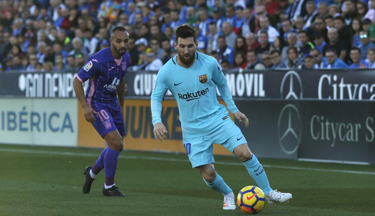 Bintang Barcelona, Lionel Messi, menggiring bola melewati striker Leganes, Nabil El Zhar, pada laga La Liga Spanyol di Stadion Butarque, Leganes, Sabtu (18/11/2017). Leganes kalah 0-3 dari Barcelona. (AP/Francisco Seco)