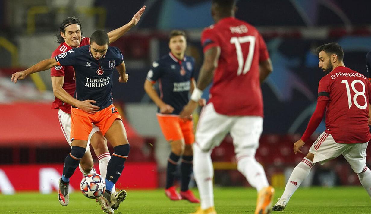 Striker Manchester United, Edinson Cavani, berebut bola dengan pemain Istanbul Basaksehir, Rafael, pada laga Liga Champions di Stadion Old Trafford, Rabu (25/11/2020). Setan Merah menang dengan skor 4-1. (AP/Dave Thompson)