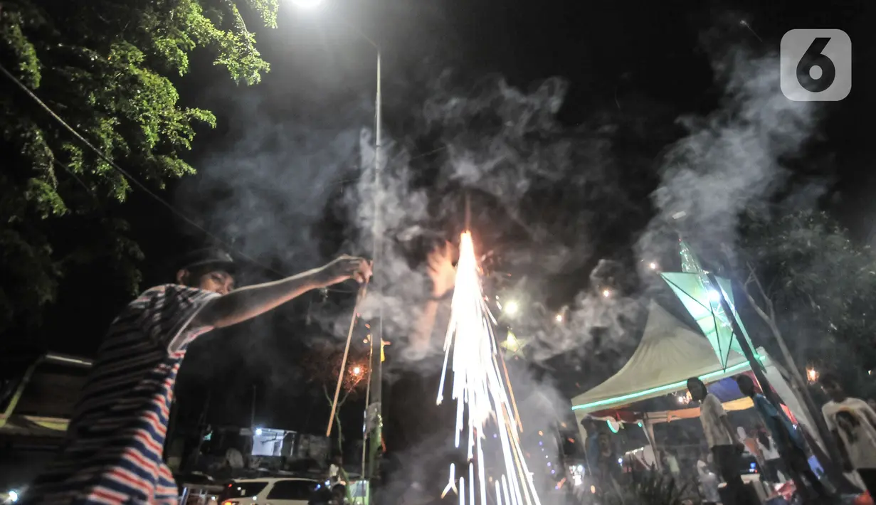 Warga menyalakan petasan saat merayakan malam takbiran Idul Fitri di Manggarai, Jakarta, Rabu (13/5/2021). Tradisi merayakan malam takbiran dengan memainkan bedug dan membuat hiasan bernuansa Islam masih terlihat di pinggiran Ibu Kota meski pandemi Covid-19. (merdeka.com/Iqbal S. Nugroho)