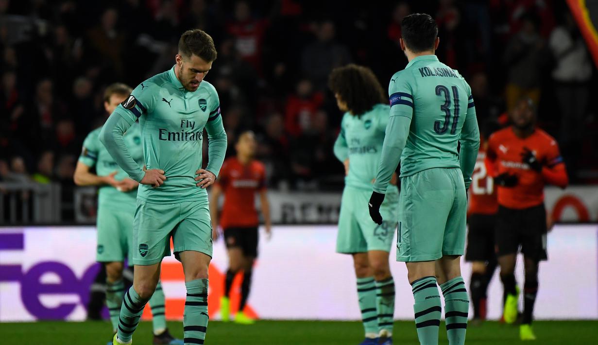 Ekspresi kecewa Aaron Ramsey pada leg 1, babak 16 besar Liga Europa yang berlangsung di Stadion Roazhon Park, Rennes, Jumat (8/3). Arsenal kalah 1-3 kontra Rennes. (AFP/Damien Meyer)