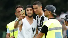 Seorang suporter Juventus berselfie dengan Cristiano Ronaldo selama pertandingan persahabatan antara Juventus A dan tim B, di Villar Perosa, Italia utara, (12/8). Suporter tersebut masuk ke lapangan pada babak pertama. (AP Photo/Antonio Calanni)