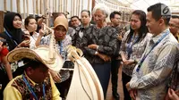 Managing Director IMF Christine Lagarde menyaksikan musikus memainkan sasando saat berkunjung ke Paviliun Indonesia di arena pertemuan IMF-Bank Dunia, Bali, Rabu (10/10). Christine terpesona dengan berbagai budaya Nusantara. (Liputan6.com/Angga Yuniar)