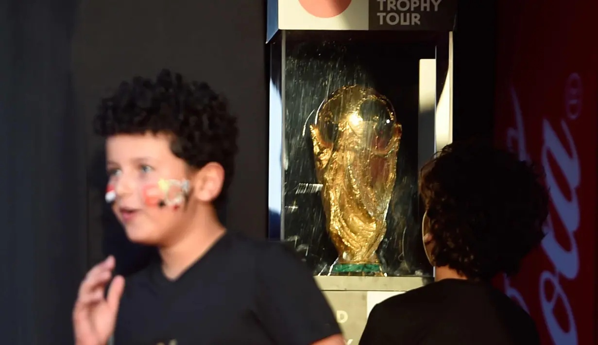 Seorang anak melihat trofi Piala Dunia FIFA  saat tur Dunia di Ibu Kota Kairo, Mesir (15/3).  Piala Dunia 2018 akan berlangsung pada bulan Juni di Rusia. (AFP Photo/Khaled Desouki)