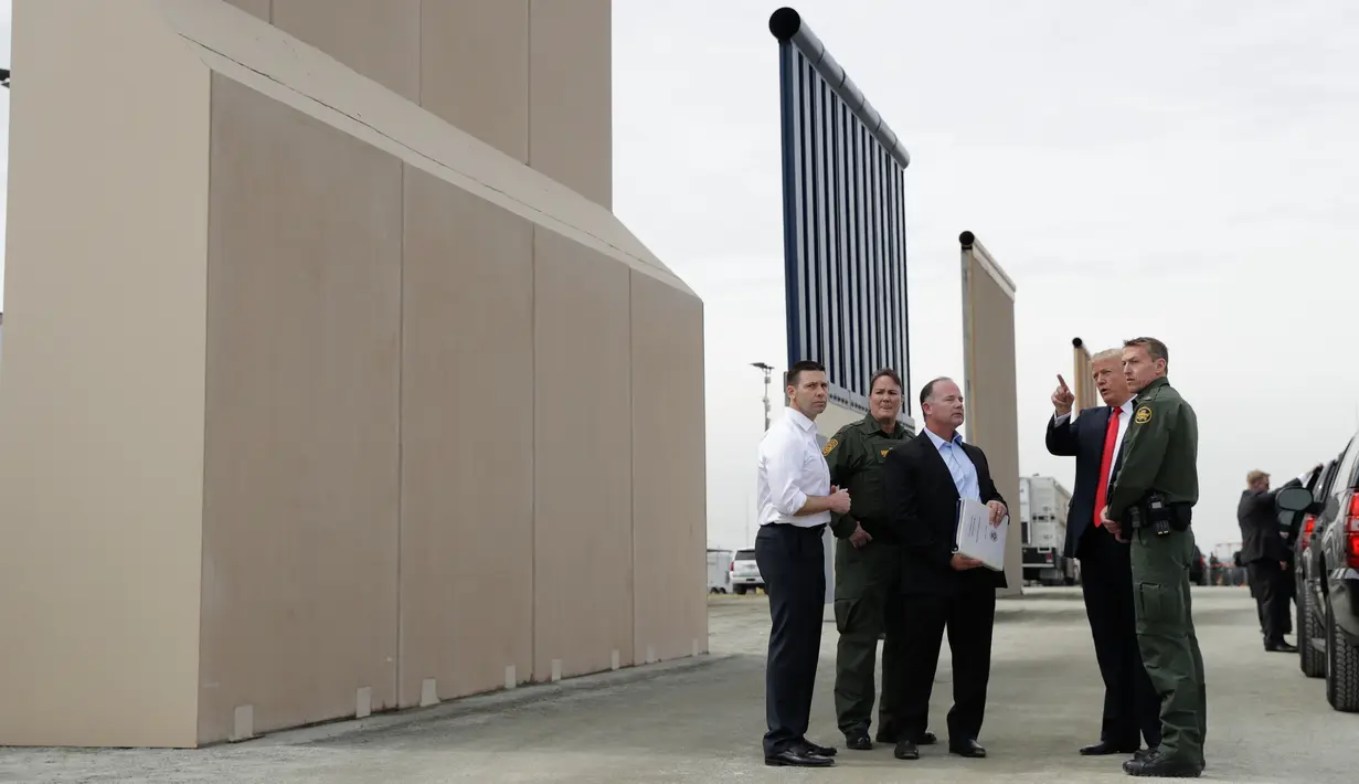 Presiden AS, Donald Trump meninjau prototipe tembok perbatasan AS dan Meksiko yang kontroversial di San Diego, Selasa (13/3). Ada sekitar delapan purwarupa panel tembok yang akan ditinjau Trump di perbatasan San Diego-Tijuana. (AP/Evan Vucci)