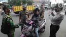 Anggota TNI-Polri menghentikan warga yang tidak mengenakan masker saat razia gabungan Kelurahan Gandul di Perempatan Gandul, Cinere, Depok, Kamis ( 29/08/2020). (merdeka.com/Arie Basuki)