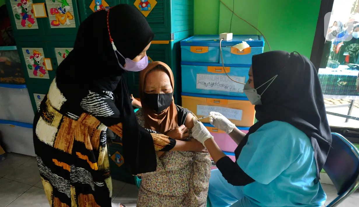Petugas kesehatan menyuntikan vaksin COVID-19 kepada warga di Balai RW 02, Jati Padang, Jakarta Selatan, selasa (28/6/20222). Munculnya COVID-19 subvarian Omicron BA.4 dan BA.5 membuat sejumlah warga antusias mengikuti vaksinasi COVID-19 yang didominasi vaksin booster.gratis beras, minyak, goreng, gula dan mie instan.  (merdeka.com/Arie Basuki)