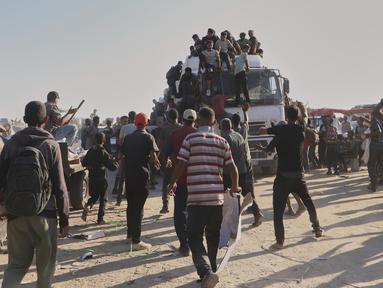 Warga Palestina mencegat dan menyerbu truk yang membawa bantuan kemanusiaan di sepanjang koridor Morag dekat Rafah, Jalur Gaza selatan, Senin, 4 Agustus 2025. (AP Photo/Mariam Dagga)