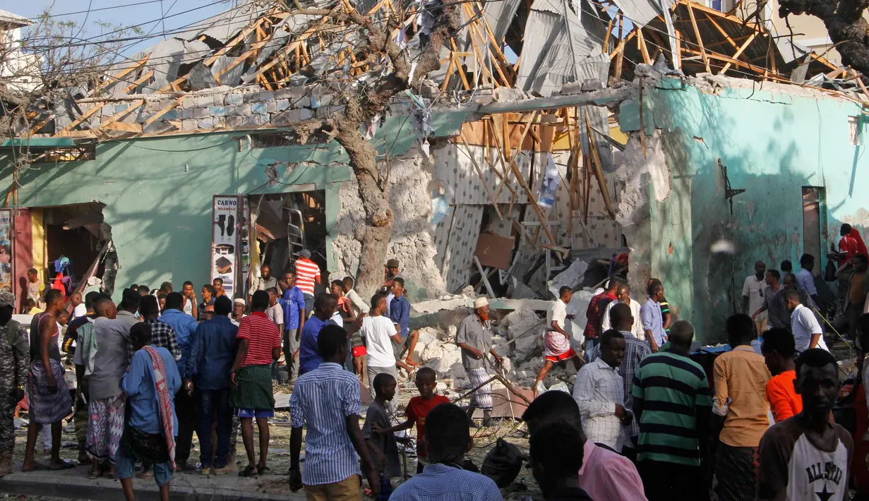 Warga berkumpul di lokasi ledakan di luar Hotel Weheliye, Jalan Maka al Mukaram, Mogadishu, Somalia, (22/3). Sedikitnya 14 orang tewas dan 10 lainnya terluka dalam ledakan bom mobil tersebut. (AP Foto/Farah Abdi Warsameh)