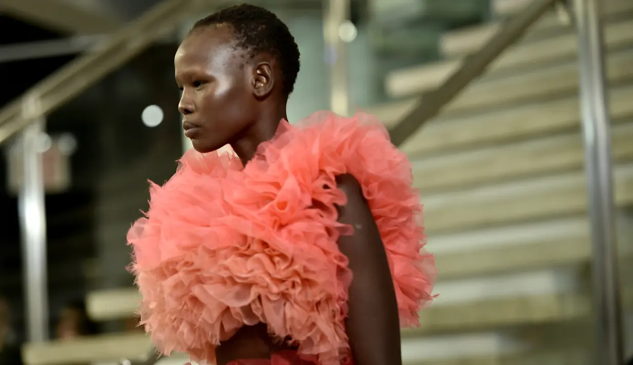 Seorang model berjalan di runway mengenakan koleksi busana rancangan desainer Jepang, Tomo Koizumi  pada New York Fashion Week di Marc Jacobs Madison, 8 Februari 2019. Koizumi menampilkan parade gaun awan berwarna pelangi (Steven Ferdman/Getty Images/AFP)