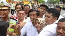 Warga berebut foto bersama seorang pria berwajah mirip Presiden Joko Widodo (Jokowi) di sekitar lokasi akad nikah Kahiyang Ayu dengan Bobby Nasution, Solo, Rabu (8/11). Pria bernama David Indrajaya itu datang dari Bandung. (Liputan6.com/Angga Yuniar)