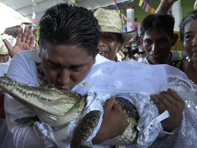 Wali Kota San Pedro Huamelula, Victor Hugo Sosa mencium buaya bernama "La Ni&ntilde;a Princesa" (Gadis Putri) sebelum menikahinya di San Pedro Huamelula, Negara Bagian Oaxaca, Meksiko, Jumat (30/6/2023). (RUSVEL RASGADO/AFP)
