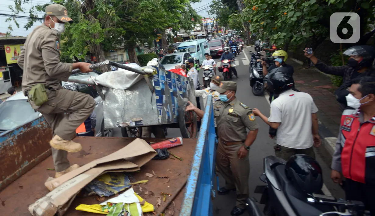 Petugas gabungan menyita gerobak saat merazia Peyandang Masalah Kesejahteraan Sosial (PMKS) di wilayah Kecamatan Duren Sawit, Jakarta Timur, Jumat (8/4/2022). Pemprov DKI Jakarta terus melakukan razia PMKS selama Ramadhan dan menjaring enam orang dalam razia kali ini. (merdeka.com/Imam Buhori)