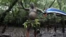 Seorang pria Bali menari dengan berlumur lumpur ditubuhnya saat mengikuti tradisi Mebuug-buugan di desa Kedonganan, Denpasar, Bali (10/3). Mebuug-buugan bertujuan untuk menetralkan sifat-sifat buruk usai hari raya Nyepi. (AFP/Sonny Tumbelaka)