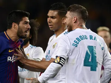 Striker Barcelona, Luis Suarez, bersitegang dengan bek Real Madrid, Sergio Ramos, pada laga La Liga Spanyol di Stadion Camp Nou, Barcelona, Minggu (6/5/2018). Kedua klub bermain imbang 2-2. (AFP/Josep Lago)