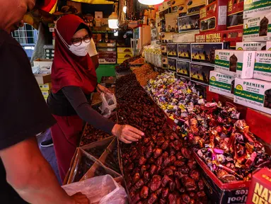 Pedagang kurma melayani pembeli di kawasan Tanah abang, Jakarta, Minggu (3/4/2022). Omset penjualan kebutuhan bulan Ramadhan seperti perlengkapan ibadah dan buah kurma kembali meningkat dibandingkan dua tahun terakhir yang terdampak pandemi COVID-19. (Liputan6.com/Johan Tallo)