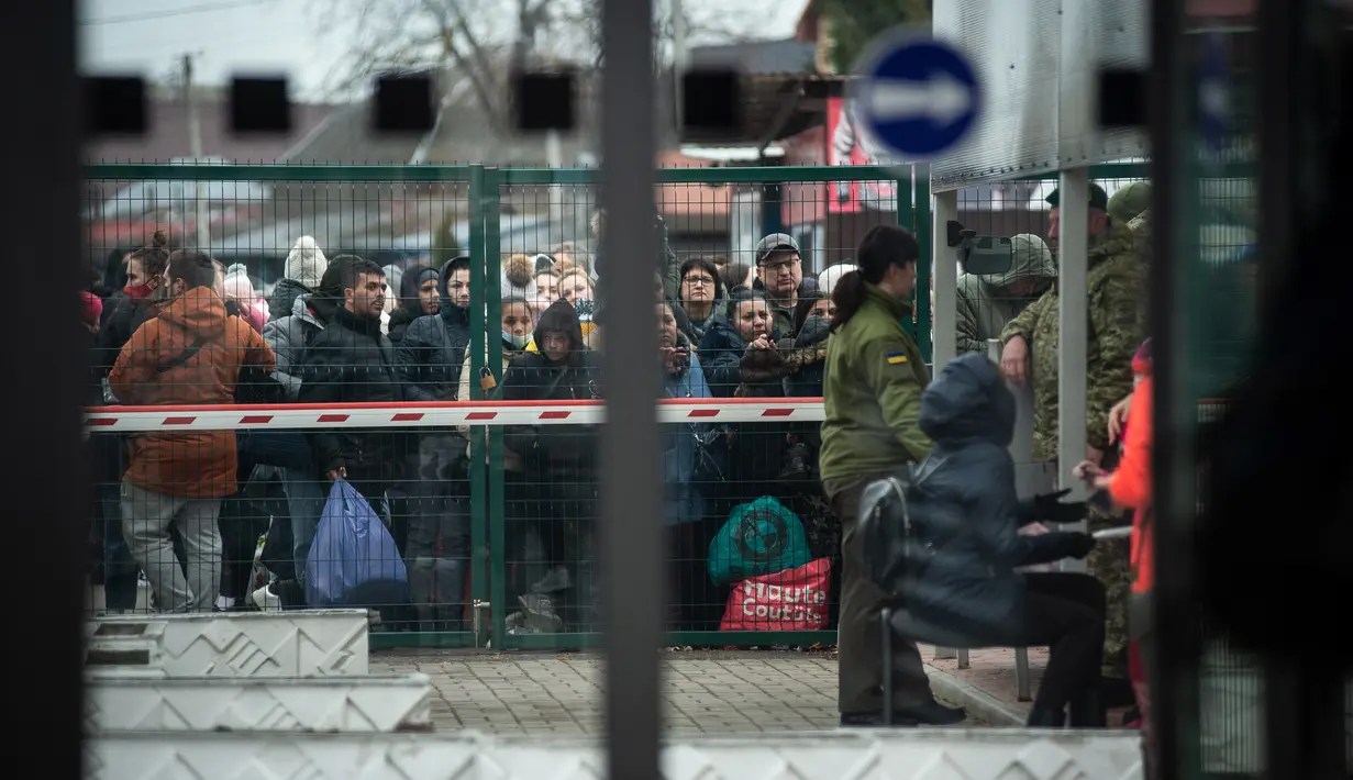 Warga Ukraina menunggu di perbatasan Slovakia-Ukraina di Velke Slemence, Slovakia (25/2/2022). Warga Ukraina mulai melarikan diri dari konflik di negara mereka sehari setelah Rusia melancarkan serangan militer. (AFP/Peter Lazar)