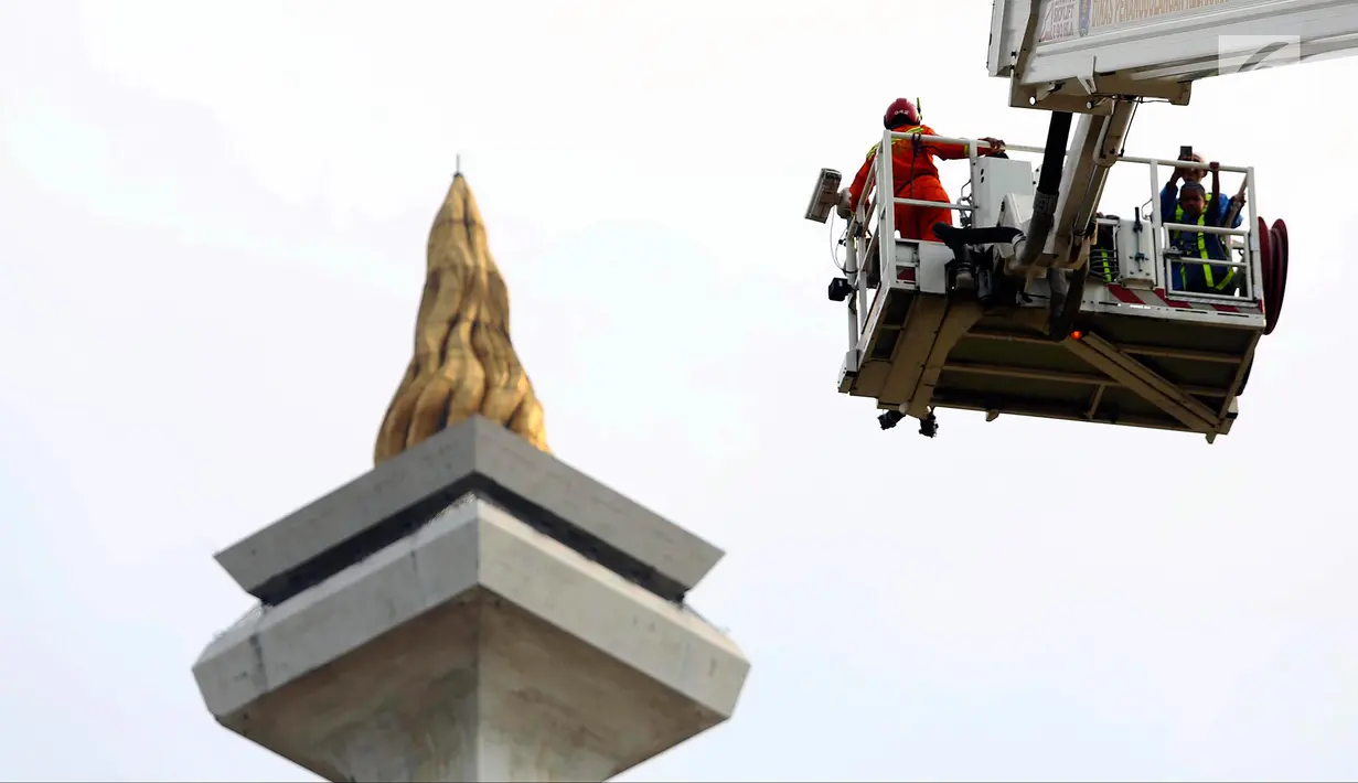 Pengunjung menaiki Bronto Skylift yang disediakan petugas pemadam kebakaran di Monas, Jakarta, Minggu (23/11). Bronto Skylift merupakan fasilitas yang disediakan Pemprov DKI Jakarta untuk melihat Monas dari dekat. (Liputan6.com/JohanTallo)