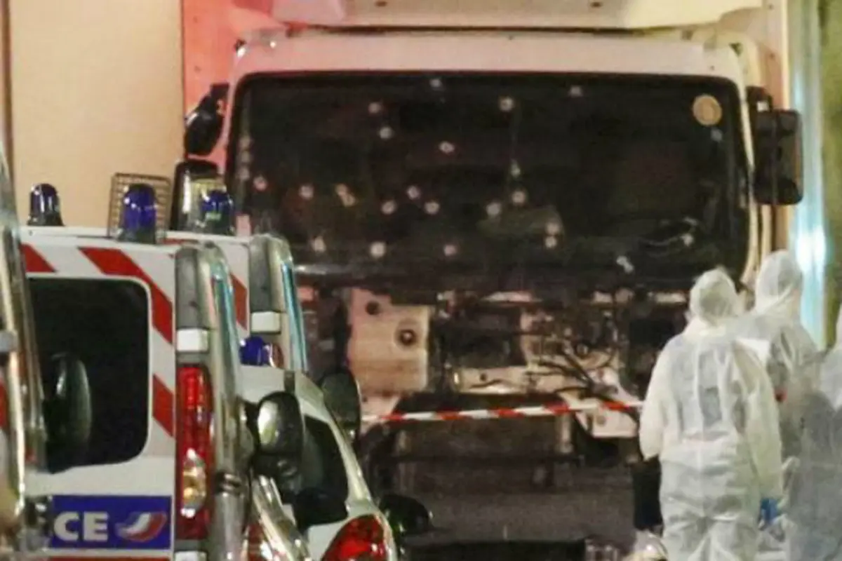 Polisi dan petugas forensik berdiri di samping truk yang menabrak puluhan warga saat merayakan Bastille Day di Nice, Prancis