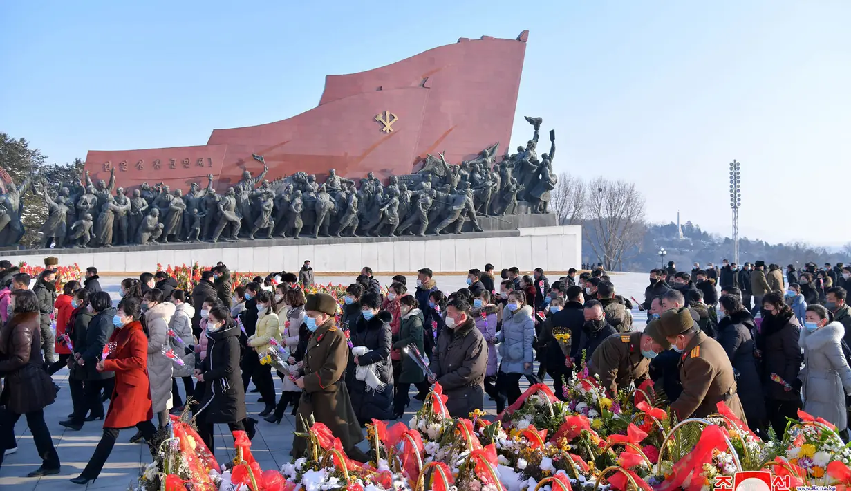 Warga dan tentara membawa bunga ke patung perunggu mantan Presiden Kim Il Sung dan mantan Ketua Kim Jong Il pada kesempatan peringatan 80 tahun kelahiran Kim Jong Il, di Pyongyang (16/2/2022). (AFP/KCNA Via KNS/STR)