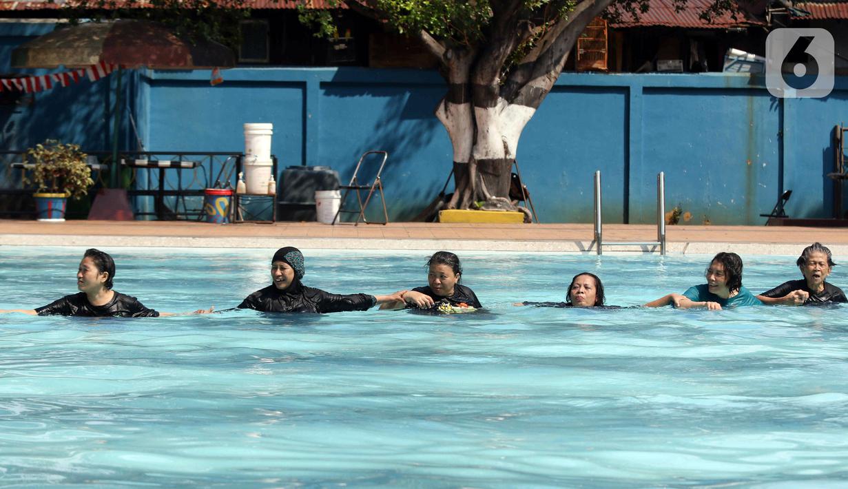 Sejumlah peserta berlatih berenang pada kegiatan Gerakan Prolanis Total (Gelato) di Gelanggang Remaja KONI, Gambir, Jakarta, Kamis (11/8/2022). Puskesmas Kecamatan Gambir mengadakan kegiatan Gelato berupa pelatihan berenang kepada peserta lansia penderita penyakit kronis untuk mencegah penyakit tersebut tambah parah. (Liputan6.com/Herman Zakharia)