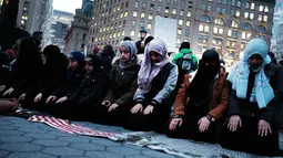 Sejumlah wanita muslim terlihat khusuk saat menggelar salat berjemaah sebelum melakukan aksi protes di Manhattan, New York (1/2). (AFP/Spencer Platt)