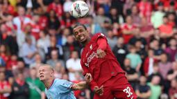 Bek Liverpool, Joel Matip (kanan) memenangi duel udara dengan striker Manchester City pada laga FA Community Shield 2022 di King Power Stadium, Leicester (30/7/2022). Joel Matip tampil di Premier League Liga Inggris bersama Liverpool yang telah diperkuatnya sejak awal musim 2016/2017. Selama 7 musim membela The Reds, ia telah tampil dalam 140 laga di Premier League dengan torehan 9 gol dan 5 assist. (AFP/Nigel Roddis)