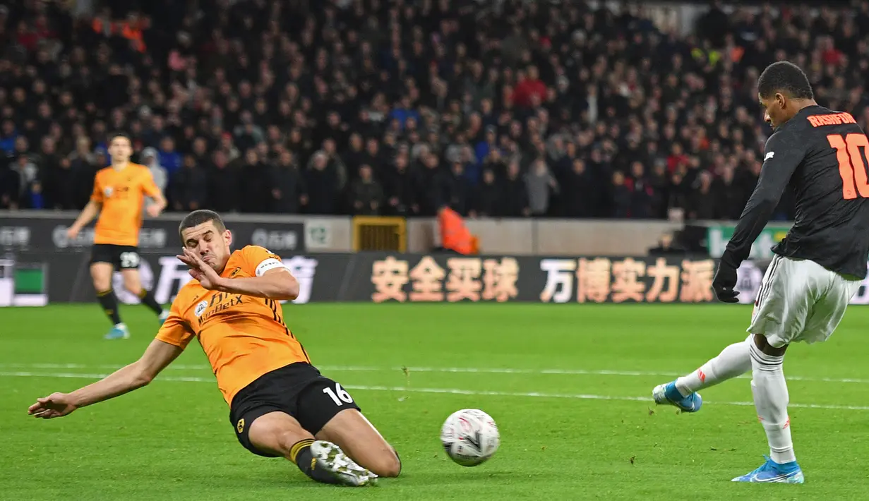 Bek Wolverhampton Wanderers, Conor Coady memblokir tendangan striker Manchester United Marcus Rashford pada babak ketiga Piala FA di Molineux, Sabtu (4/1/2020). Wolverhampton dan MU dipaksa untuk melakukan laga ulangan di Old Trafford usai bermain imbang tanpa gol. (Justin TALLIS/AFP)