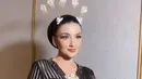 Kebaya elegan tersebut dipadukan bawahan kain dasar hitam dengan corak batik warna gold. Serta melengkapi tampilan dengan tiga bros berbeda ukuran dari besar dan sedang warna keemasan. Ia pun mengenakan anting-anting silver minimalis.  [@bennusorumba]