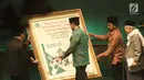 Menkopolhukam Wiranto menandatangani poster buku Penggerak Ulama Pelindung Umat pada acara Milad MUI ke-42 dan Anugerah Syiar Ramadhan 2017 di Jakarta, Kamis malam (26/7). (Liputan6.com/Herman Zakharia)