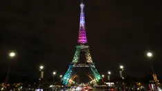 Pengunjung berjalan di sekitar Menara Eiffel yang diterangi dengan huruf bertuliskan '300 juta terima kasih' di Paris, Kamis (28/9). Menara Eiffel pada Kamis waktu setempat merayakan pengunjung ke-300 jutanya sejak dibuka pada 1889. (LUDOVIC MARIN/AFP)