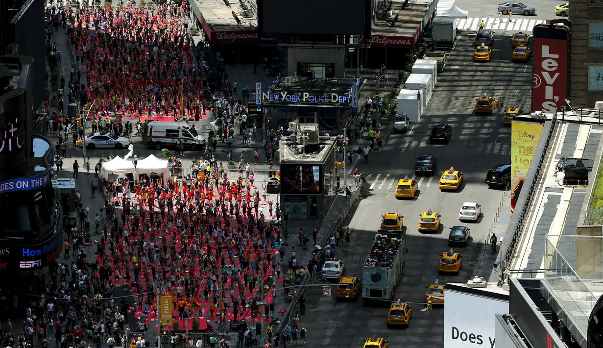 Suasana saat ribuan orang berlatih yoga di tengah jalan saat perayaan Summer Solstice di Hari Yoga Internasional di Times Square, New York, Minggu (21/6/2015). (REUTERS/Eduardo Munoz)