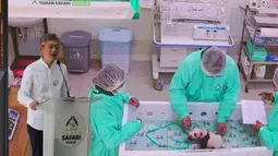 Rio lahir melalui proses inseminasi buatan (ART) yang keempat setelah penantian selama 9 tahun. Tampak dalam foto, Duta Besar China untuk Indonesia, Wang Lutong memberi keterangan di depan video yang menampilkan staf saat merawat Satrio Wiratama, yang dijuluki 'Rio', anak panda raksasa pertama yang lahir di Indonesia, yang ditampilkan di layar selama konferensi pers di Taman Safari Indonesia, Bogor, Jawa Barat, Selasa 6 Januari 2026. (AP Photo/Dita Alangkara)