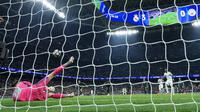 Kiper Manchester City, Gianluigi Donnarumma, melakukan penyelamatan terhadap eksekusi penalti penyerang Real Madrid, Vinicius Junior, pada leg pertama 16 besar Liga Champions 2025/2026 di Santiago Bernabeu, Kamis (12/3/2026) dini hari WIB. (Thomas COEX / AFP)