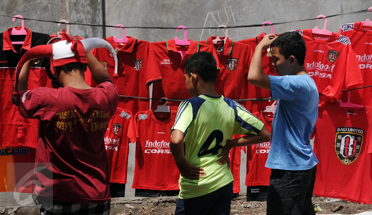 Beberapa suporter memilih kaos tim kesayangan mereka di Stadion I Wayan Dipta, Gianyar, Bali, Minggu (30/8/2015). Jelang pembukaan turnamen Piala Presiden 2015, ribuan suporter menyerbu stadion Dipta, Gianyar, Bali. (Liputan6.com/Helmi Fithriansyah) 