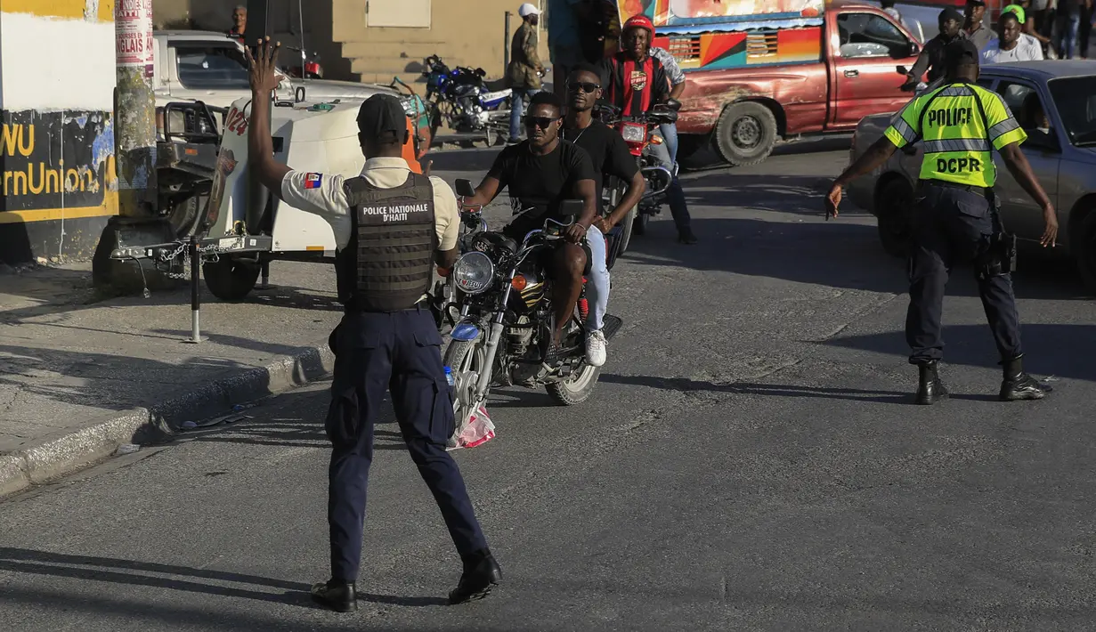 Polisi nasional mengontrol keamanan di sebuah jalan di Port-au-Prince, Haiti, Sabtu (21/1/2023). Kelompok hak asasi manusia mengatakan kelompok bersenjata sekarang menguasai lebih dari setengah wilayah Haiti. (AP Photo/Megan Janetsky)